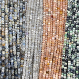 Kyanite, labradorite, peach moonstone, variscite 2mm cube faceted beads displayed from left to right in order.