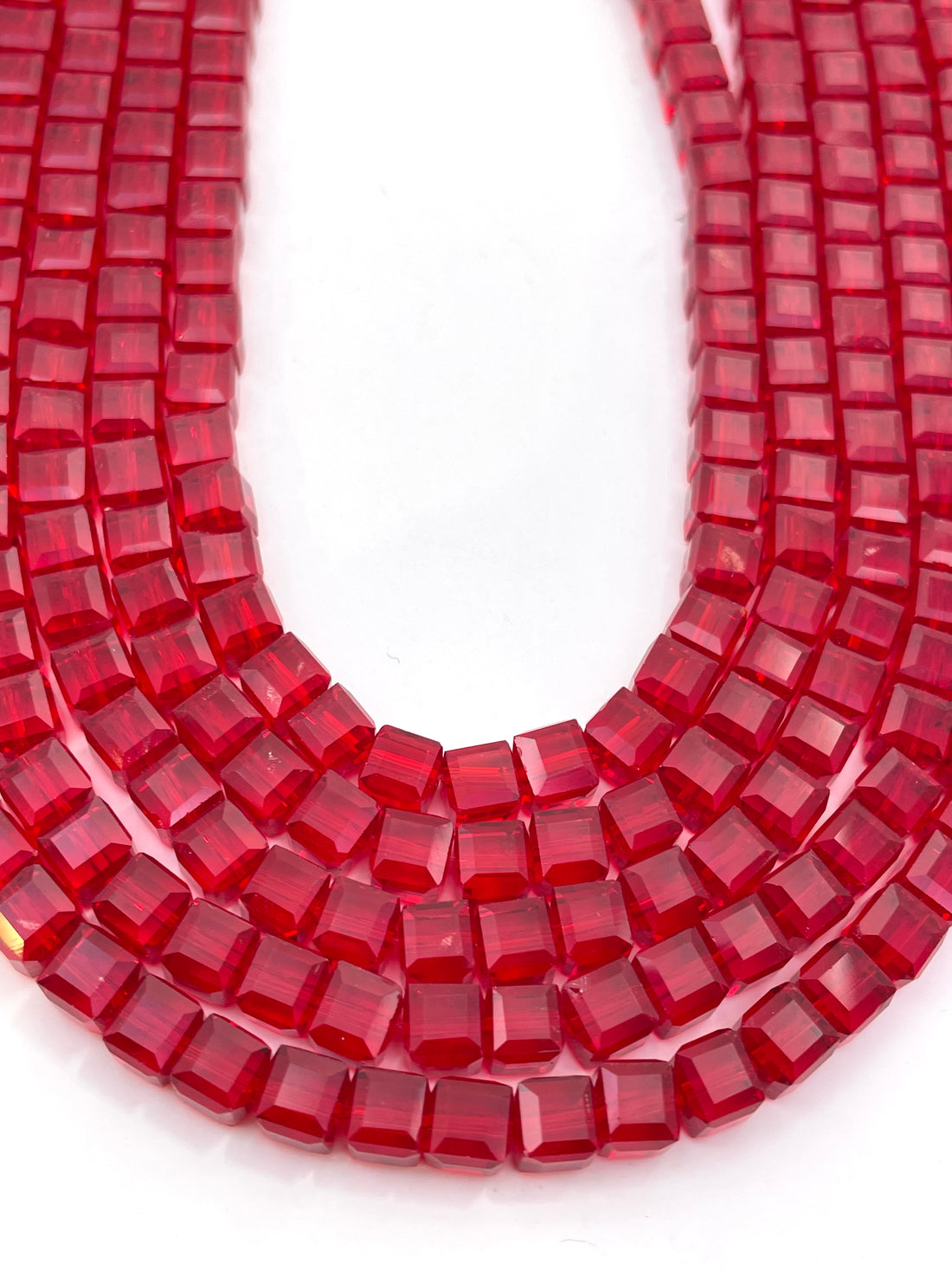 Red faceted glass beads on a white background.