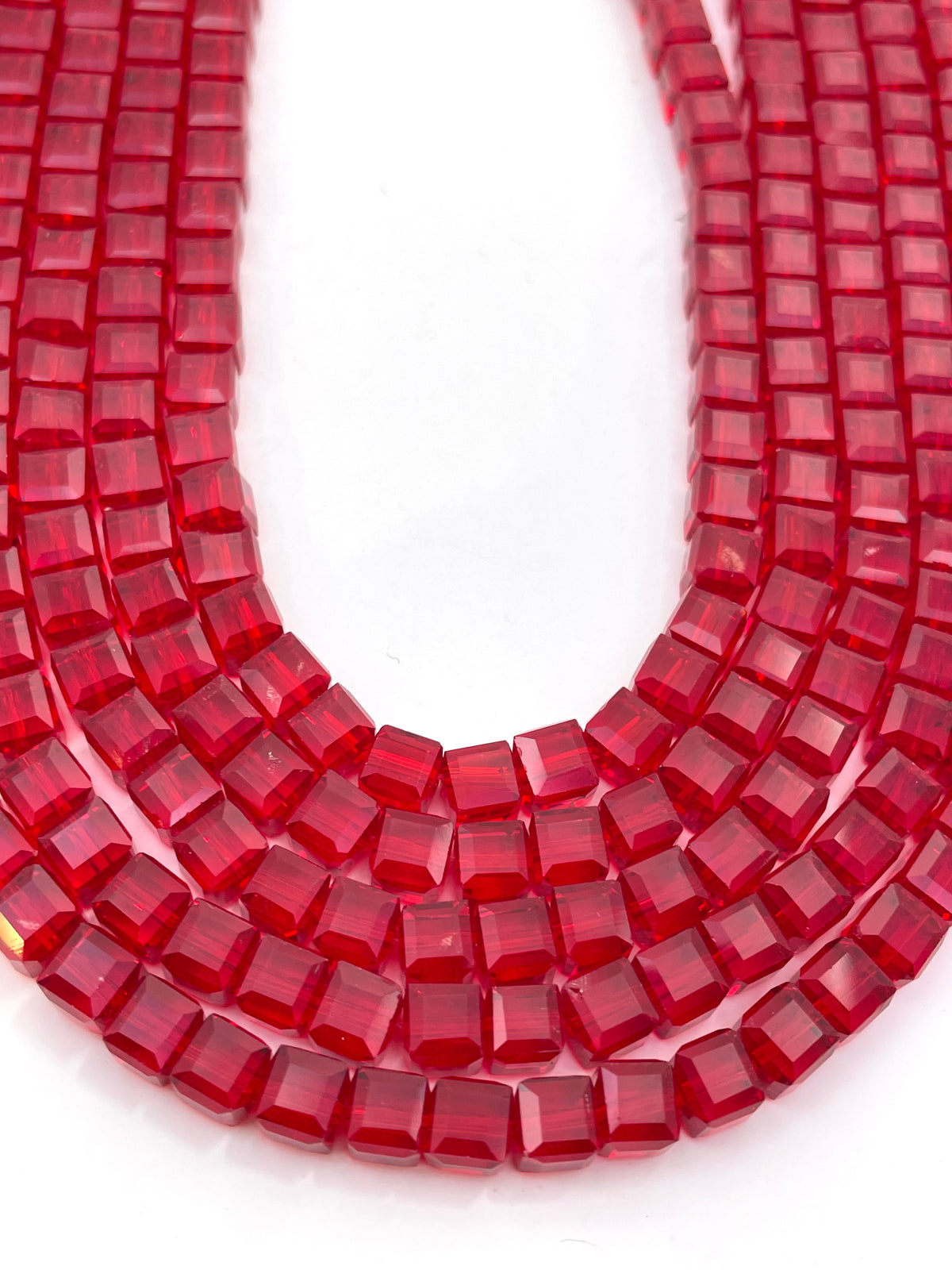 Red faceted glass beads on a white background.