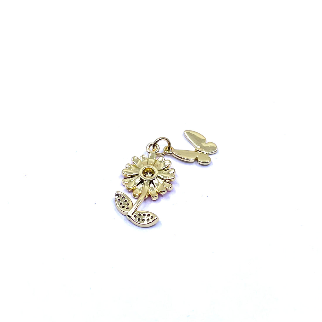 A gold-tone metal charm featuring a pink daisy flower with a clear rhinestone center and two small butterfly charms, shown on a plain white background.