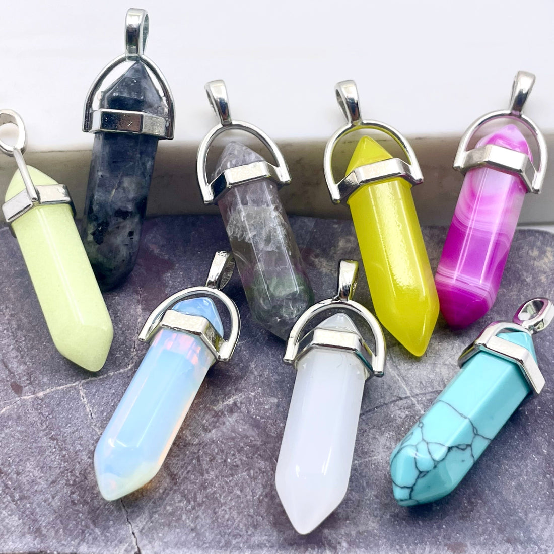 Blue howlite, pink agate, lemon jade, flourite, larvikite, white jade, opalite and glow in the dark hexagonal pendants
