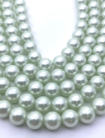 Multiple strands of round, lustrous shell pearl beads in a pale mint green color, arranged in a U-shape on a plain white background.