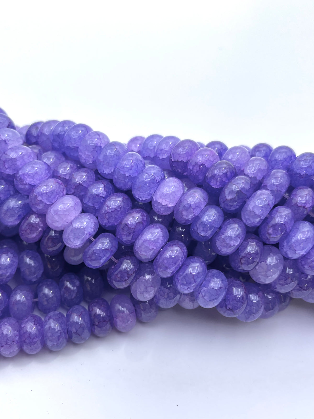 Smooth donut purple glass beads twisted onto each other 