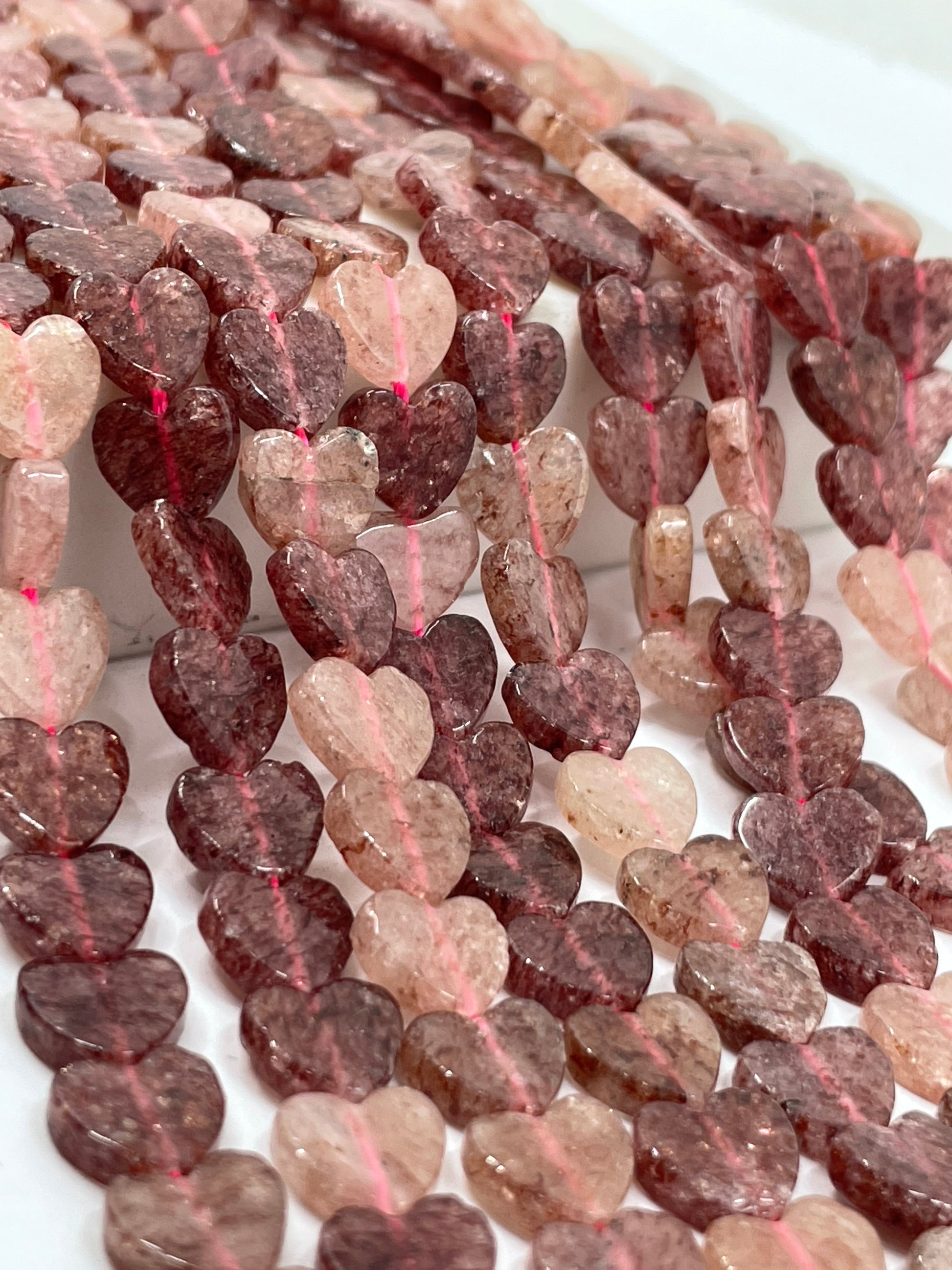 Close-up of strawberry quartz heart beads
