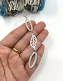 Leaf and oval link chain on hand for size reference