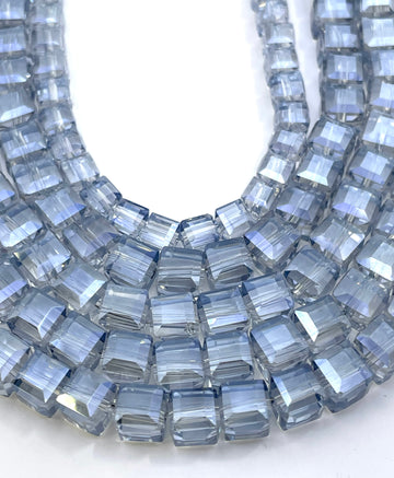 Light montana blue glass beads arranged in curved pattern.