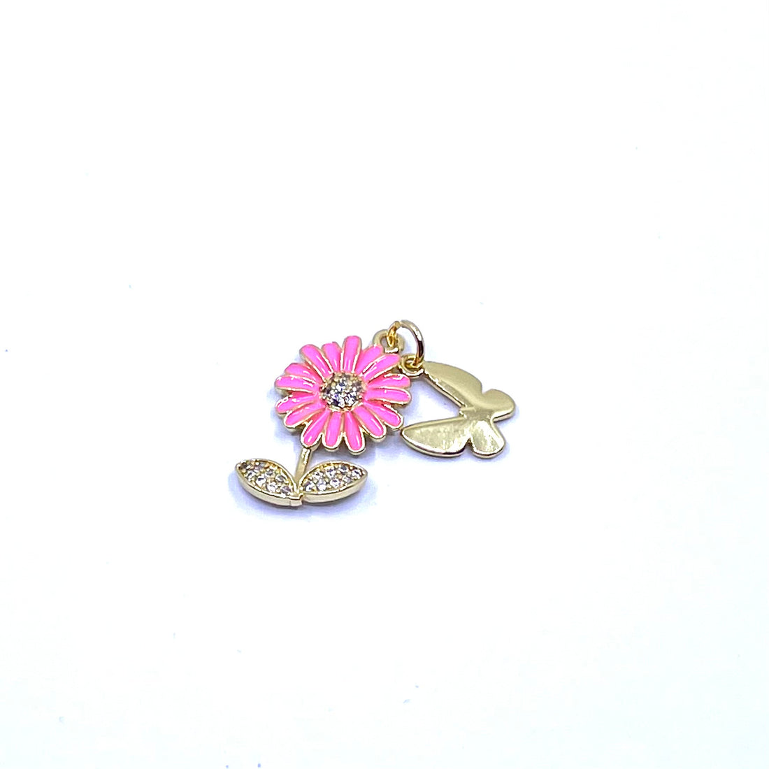 A gold-tone metal charm featuring a pink daisy flower with a clear rhinestone center and two small butterfly charms, shown on a plain white background.