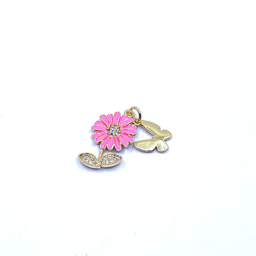 A gold-tone metal charm featuring a pink daisy flower with a clear rhinestone center and two small butterfly charms, shown on a plain white background.