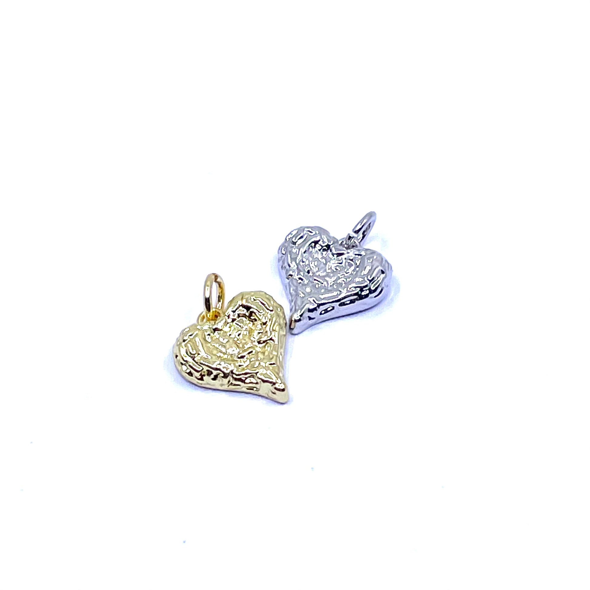 Two textured heart-shaped charms, one in yellow gold and one in silver, shown on a plain white background.