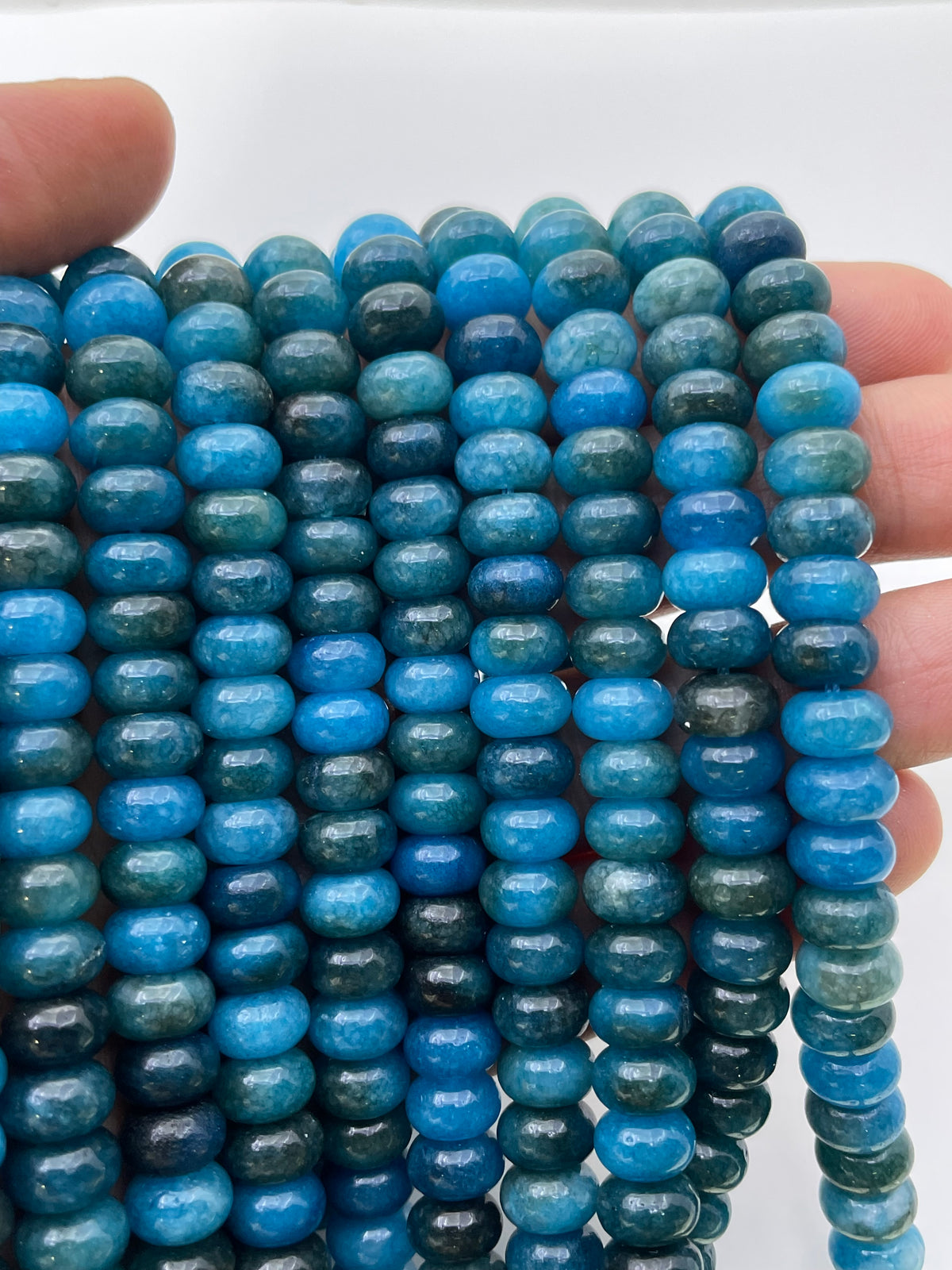 Apatite jade beads shown on hand for size reference