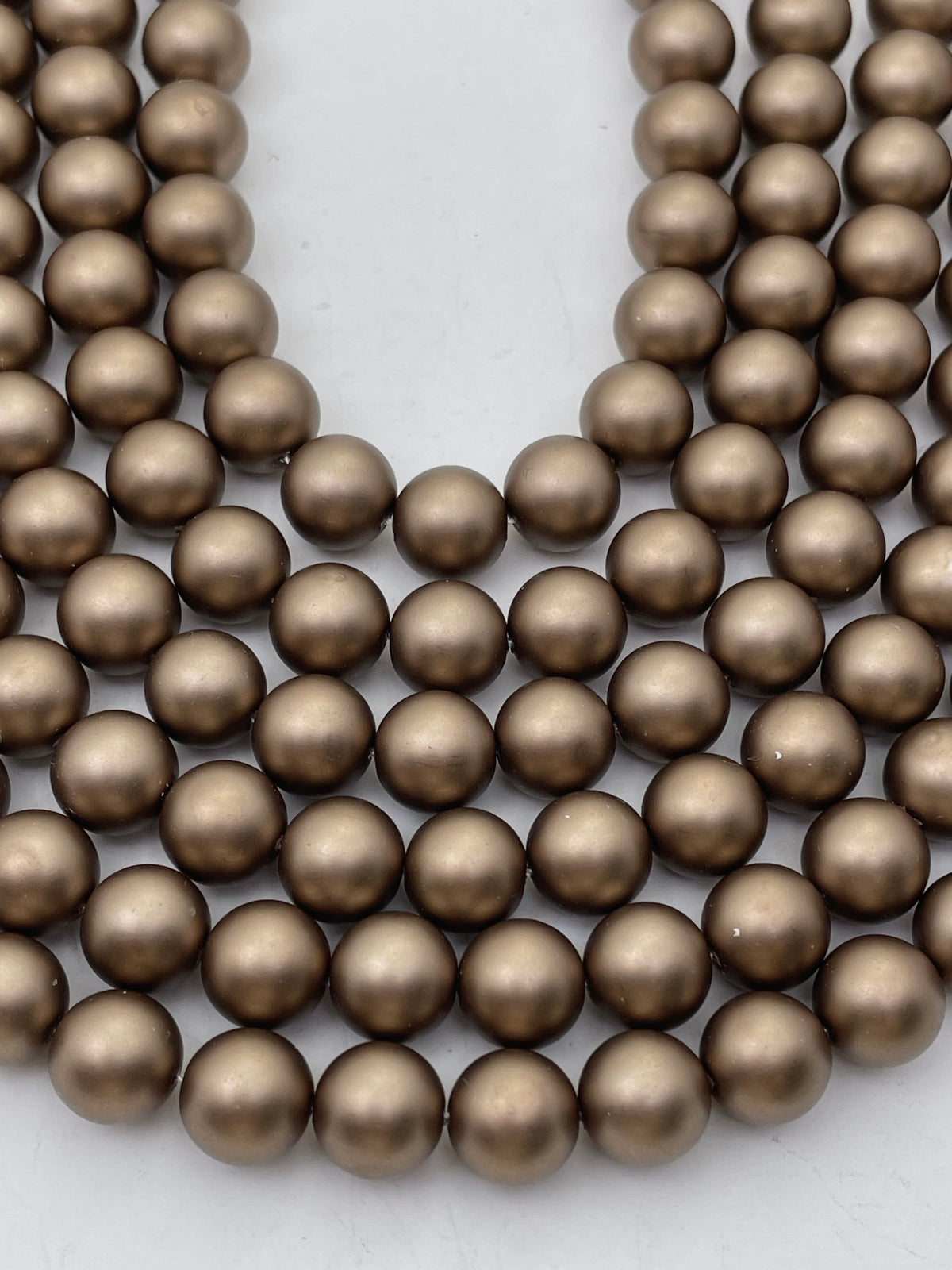Pearlescent Chocolate Brown Shell Pearls shown in curved strands