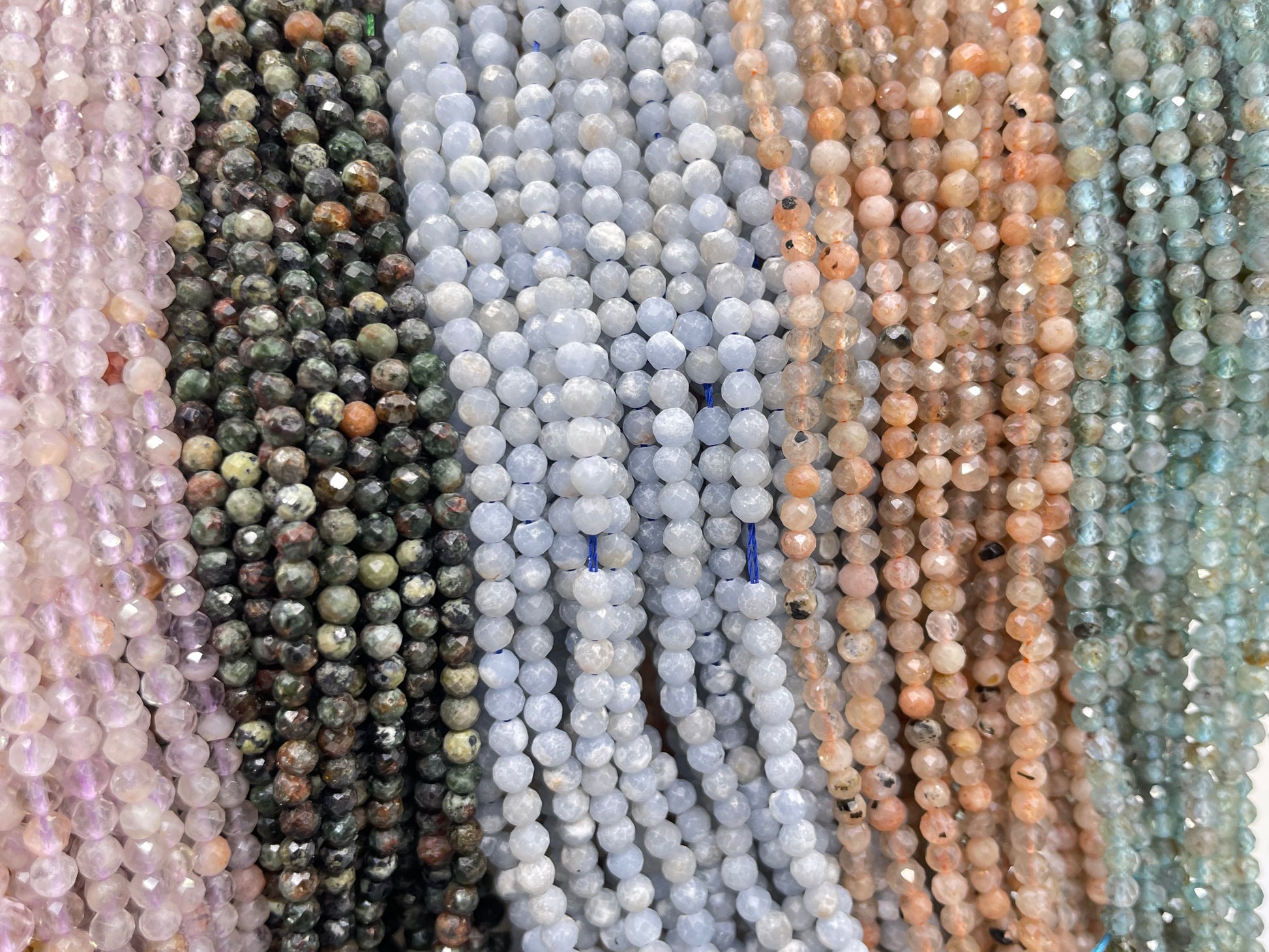 3mm round faceted light amethyst, serpentine, angelite, sunstone and light apatite displayed from left to right.