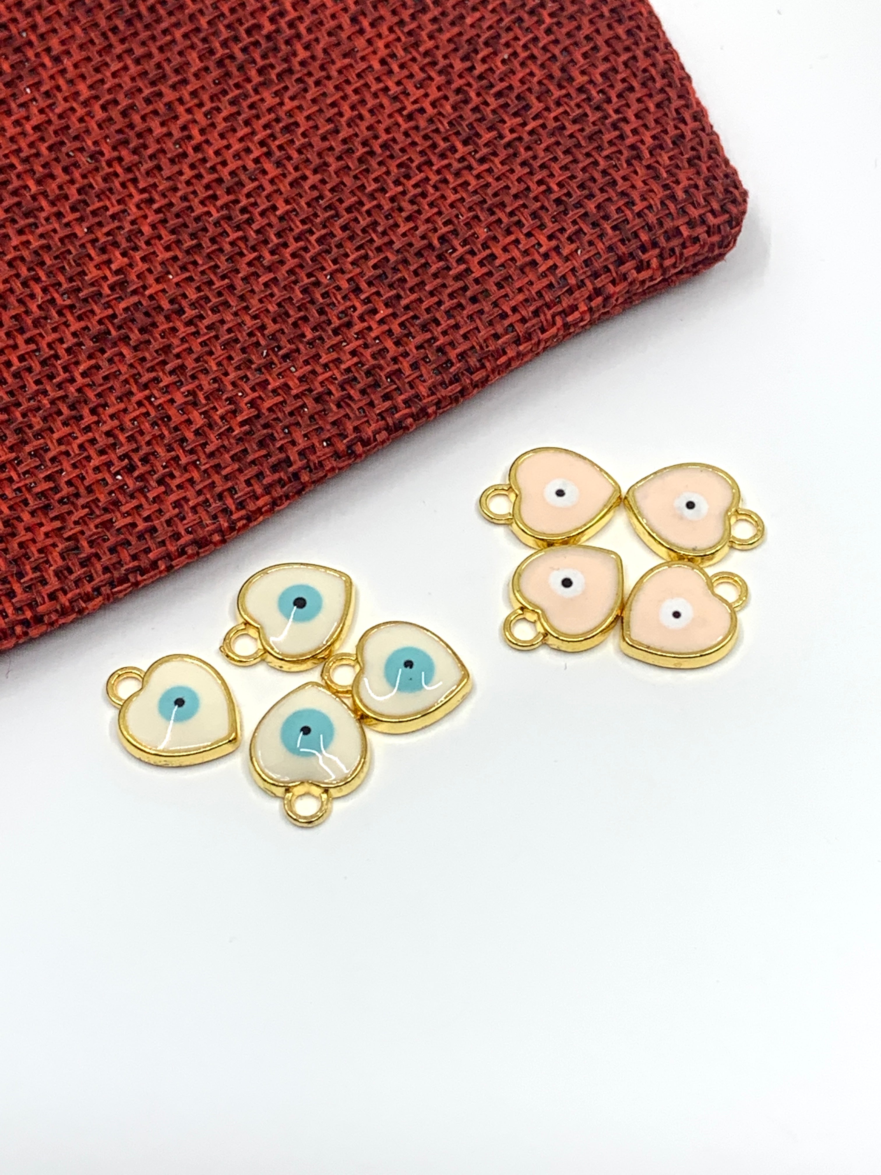 White and pink enamel heart evil eye charms