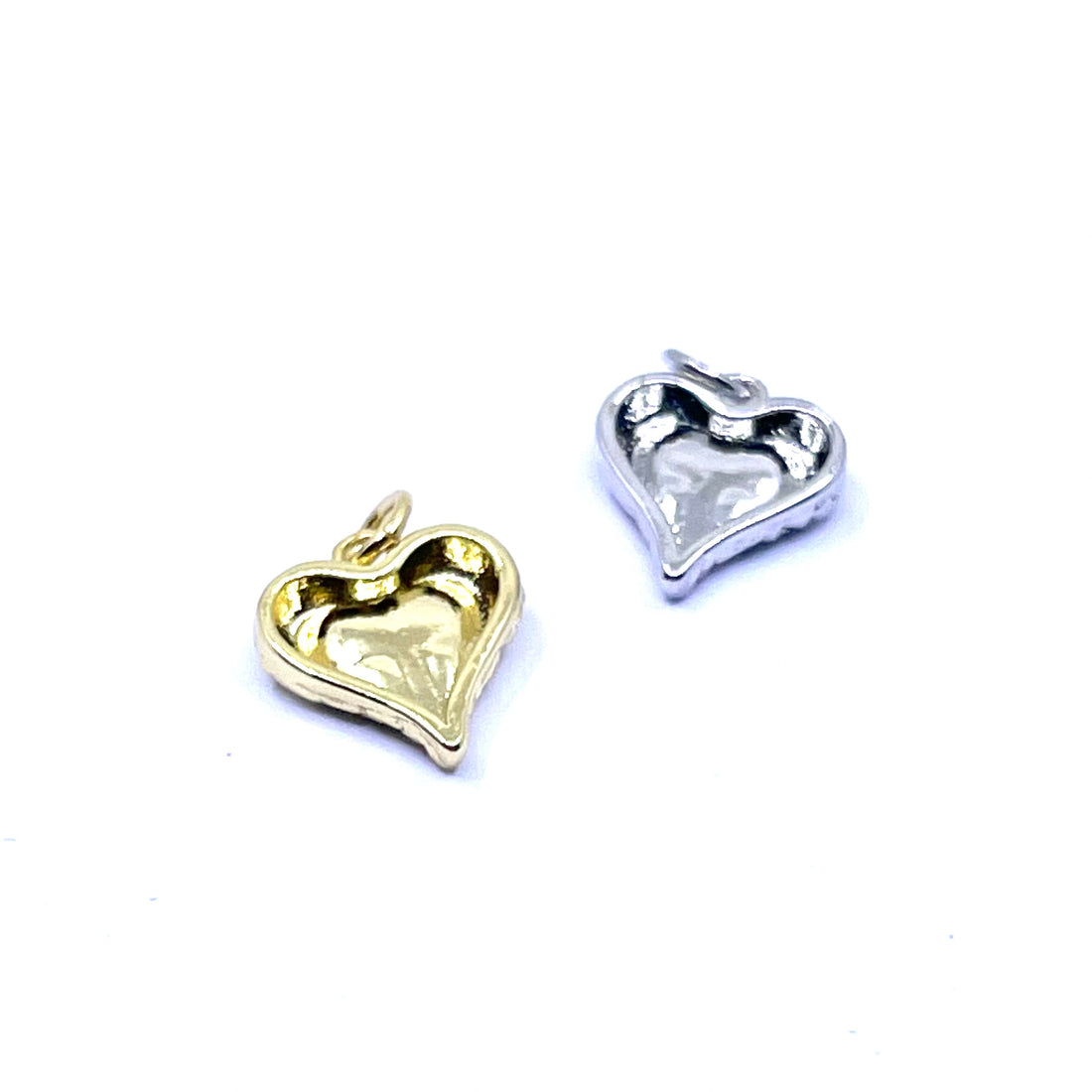 Two textured heart-shaped charms, one in yellow gold and one in silver, shown on a plain white background.