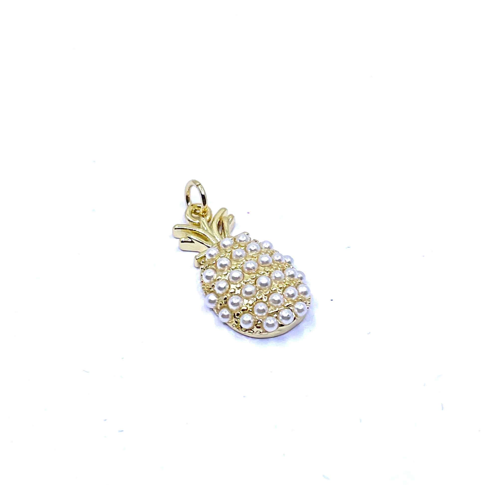 A gold pineapple-shaped charm embellished with small white faux pearls, shown on a plain white background.