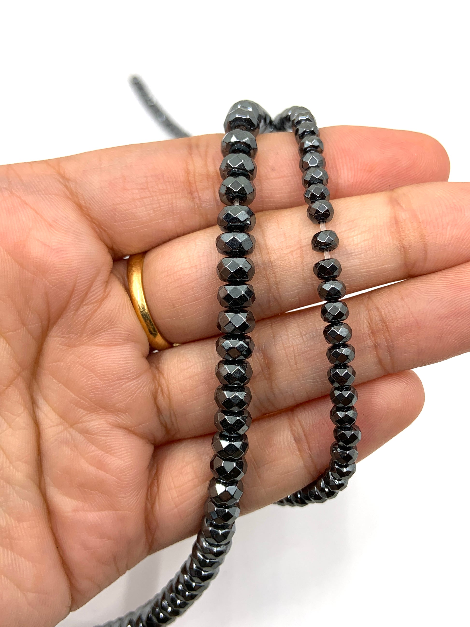 Faceted hematite beads on hand for size reference