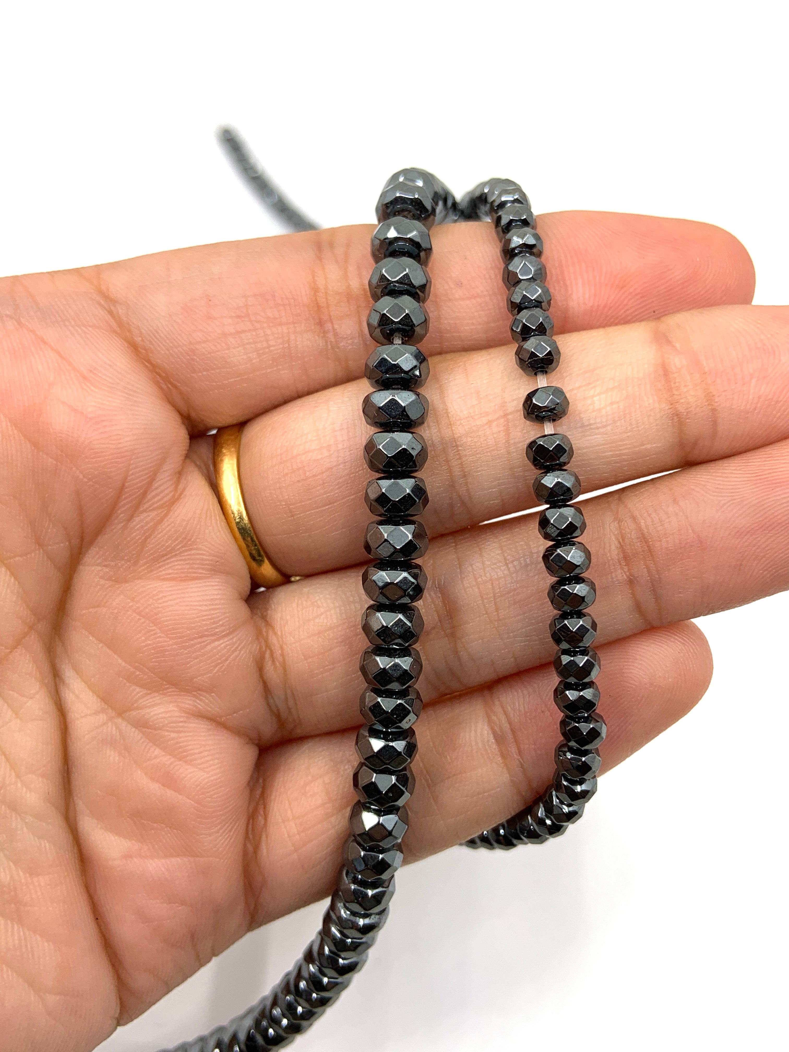 Faceted hematite beads on hand for size reference