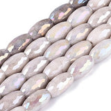 Row of faceted gemstones with iridescent surface on a white background