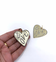 Big Heart Necklace Pendant with Love Writing on it shown on hand for size reference 