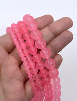Transparent pink jade beads on hand for size reference