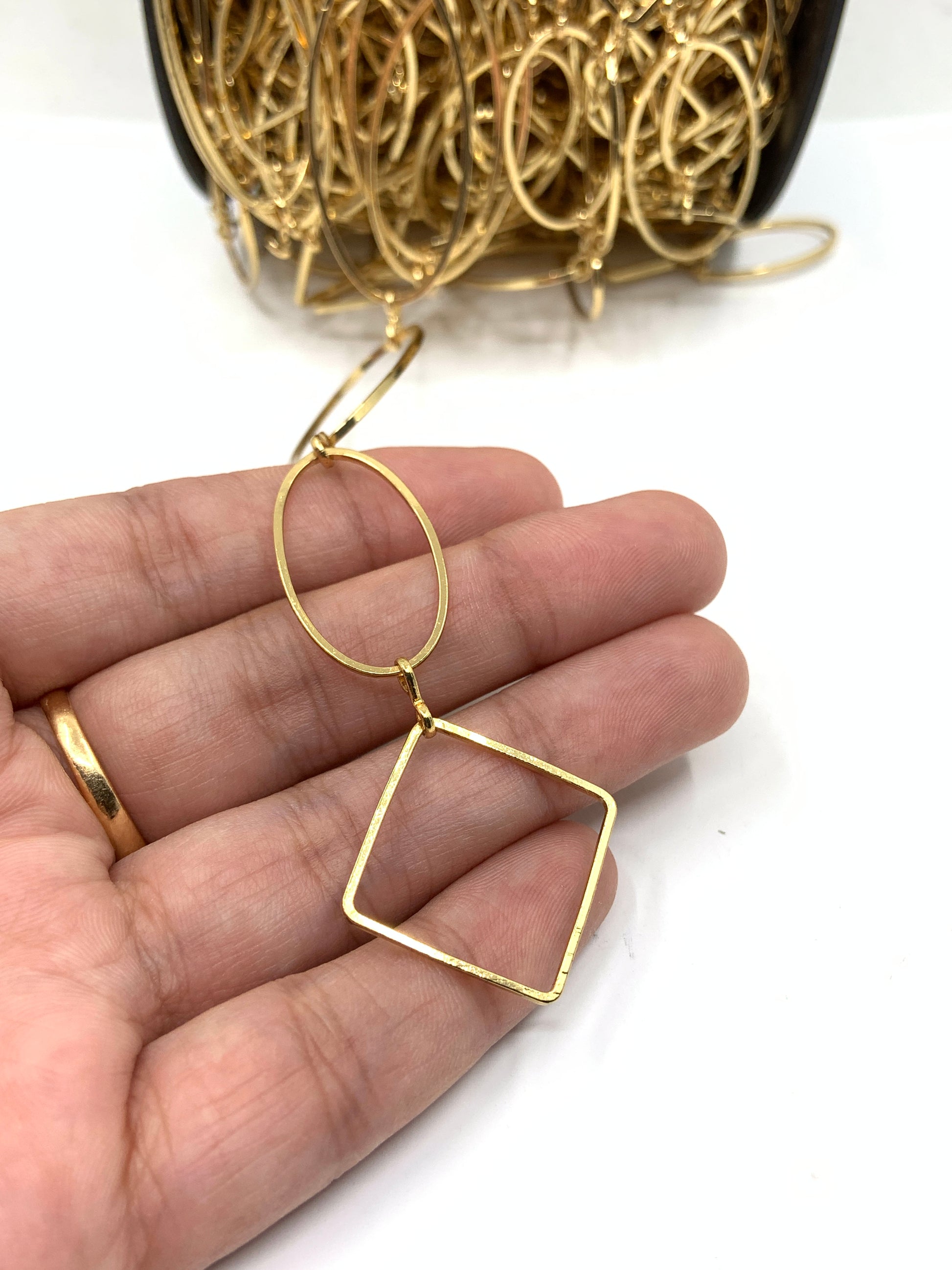 Dull gold link chain on hand for size reference