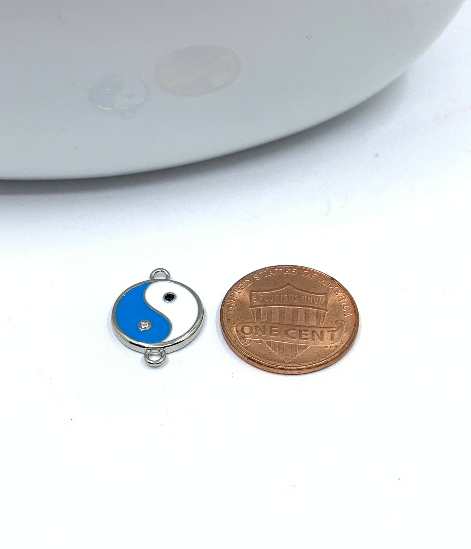 Enamel yin yang connector with a coin for size reference