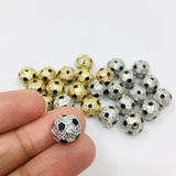Soccer ball beads shown on hand for size reference