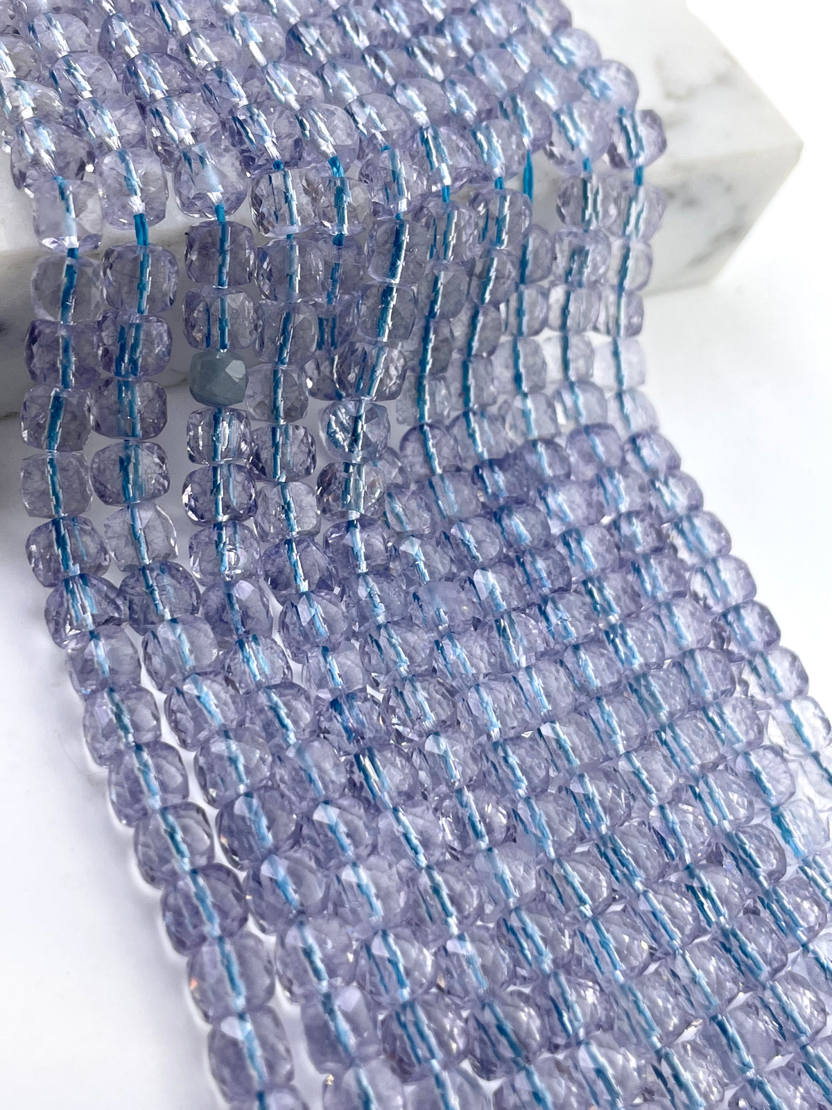 5mm cube faceted topaz beads against a white background