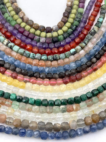 Cube faceted gemstone beads curved against white backround