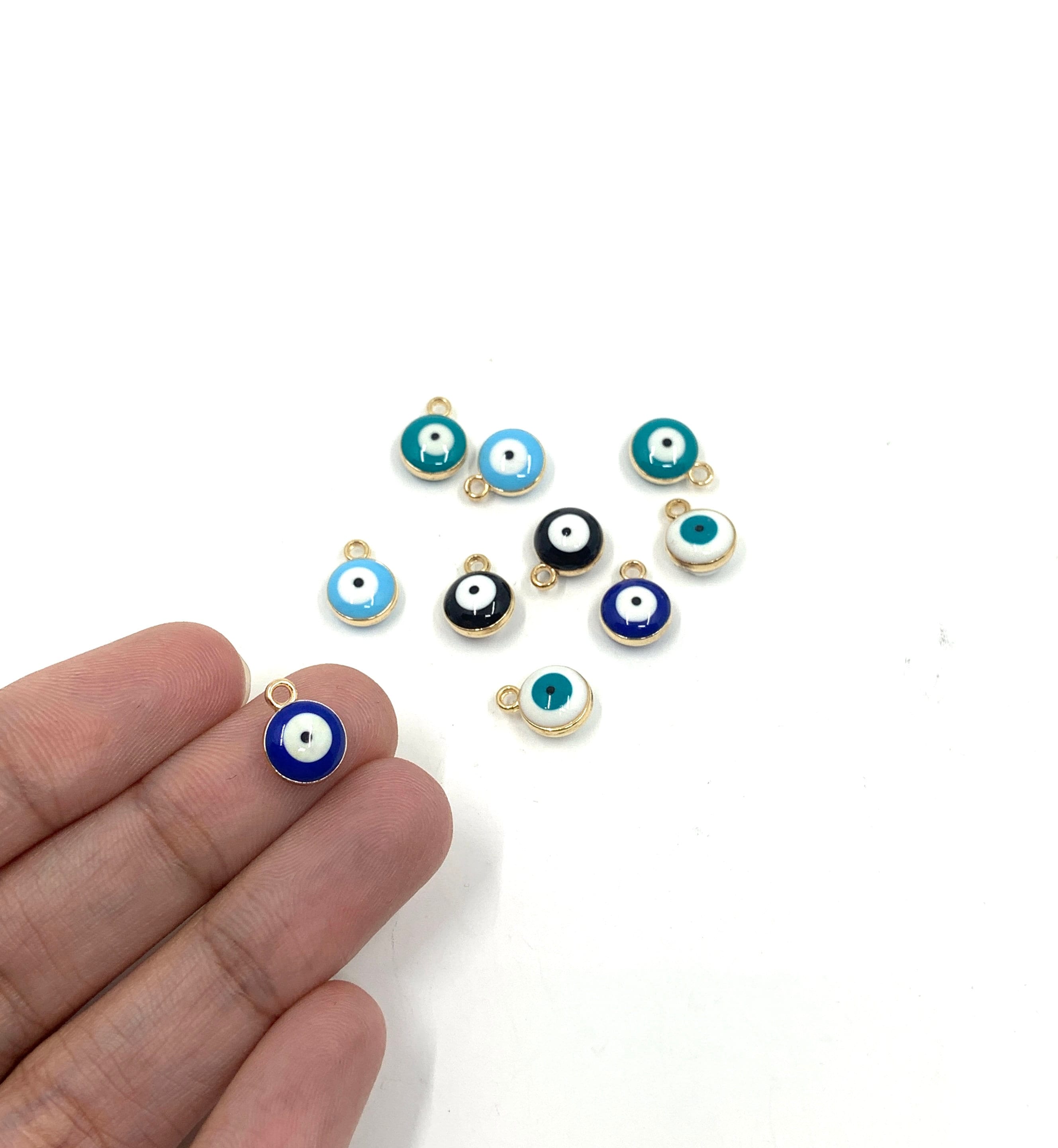 Evil eye charms shown on hand for reference.