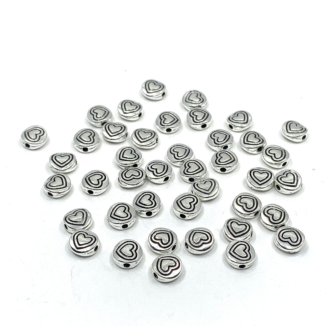 40 heart beads, flat round shape. Heart in heart pattern drawn on beads.