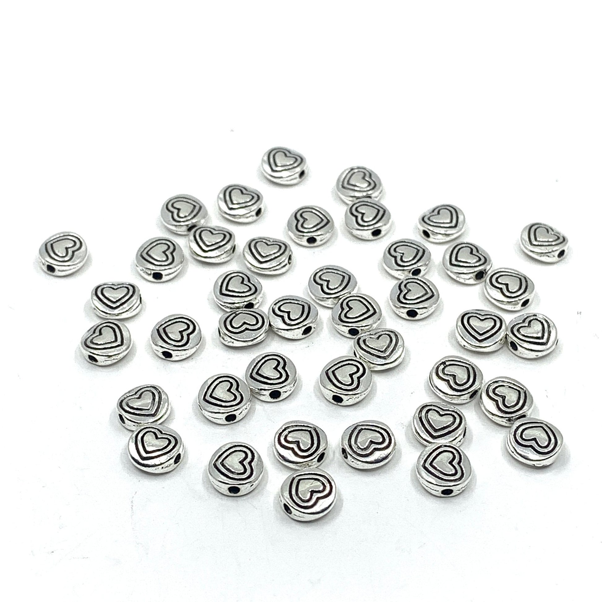 40 heart beads, flat round shape. Heart in heart pattern drawn on beads.