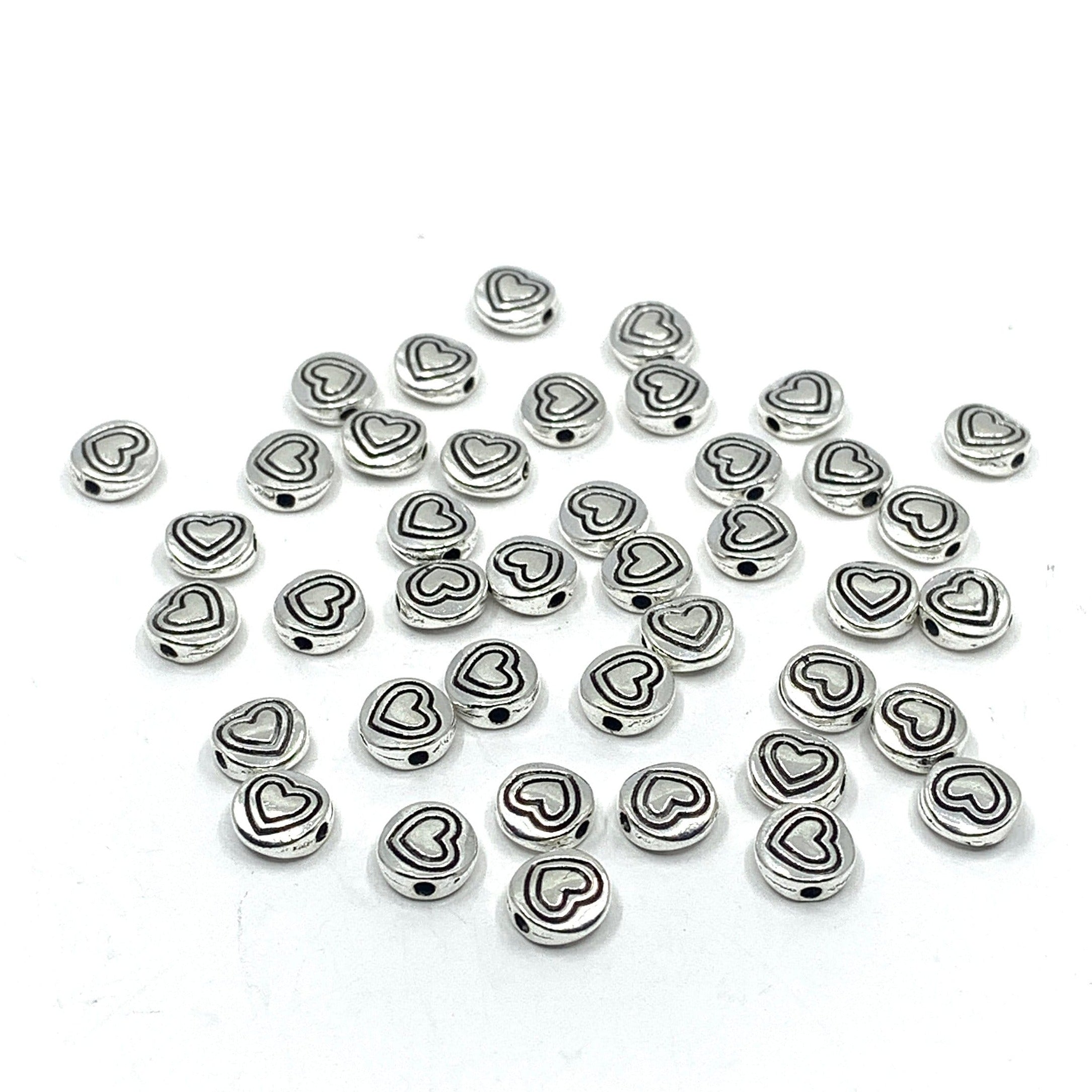 40 heart beads, flat round shape. Heart in heart pattern drawn on beads.