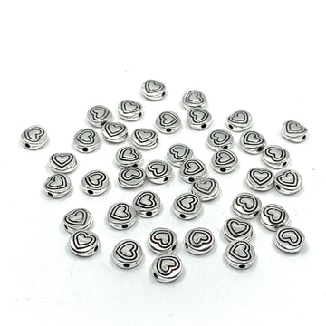40 heart beads, flat round shape. Heart in heart pattern drawn on beads.